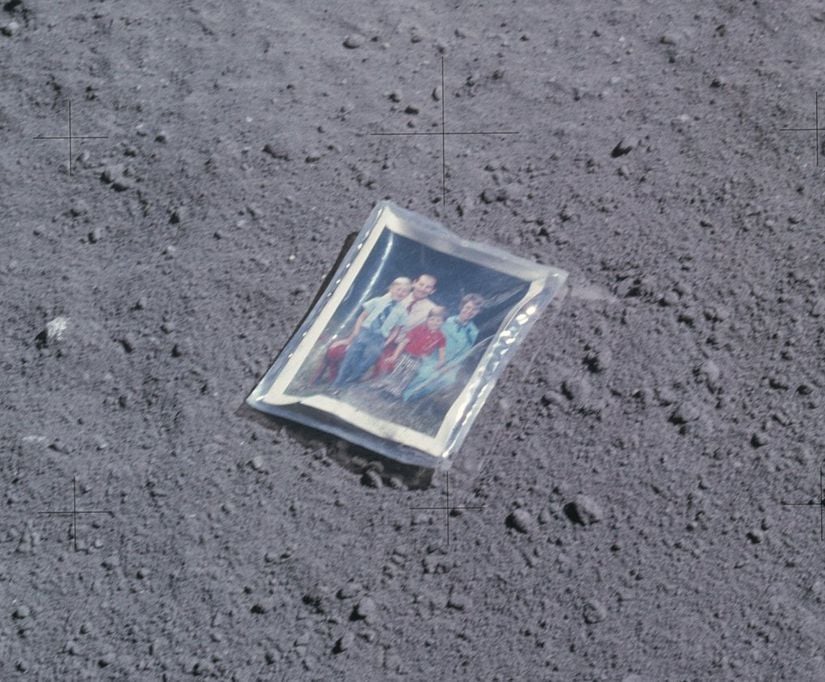 NASA astronotu Charles Duke, Ay yüzeyine Güneş’ten yayılan enerjiyi ölçen bir cihaz yerleştirecekti. Bunu yapmadan önce, Ay’ın yüzeyine küçük bir aile fotoğrafı koydu. Ardından, Hasselblad kamerası ile Ay yüzeyinde bıraktığı izin birkaç fotoğrafını çekti. Fotoğraf, Charlie, eşi Dorothy ve oğulları Charles ve Thomas’ı içeriyordu. Charlie, plastik bir koruyucu kılıf içinde yer alan ve astronot giysisi nedeniyle kırıştığı belli olan fotoğrafı yere bıraktı. Fotoğrafın arkasında, belki bir gün uzaylılar tarafından bulunma ihtimaline karşı olsa gerek, bir de not düştü: "Bu fotoğraf, Ay’a Nisan 1972’de inen, Dünya gezegeninden astronot Duke’un ailesine aittir."
