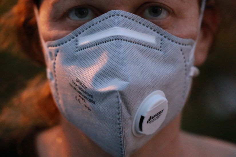 Salgına karşı maskeli önlem almış bir kadın.