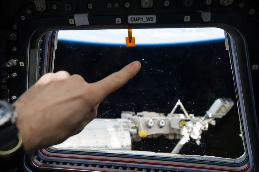 Window on ISS with damage from space Debris